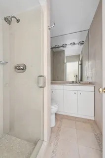 a bathroom with a white bath tub a mirror and a shower