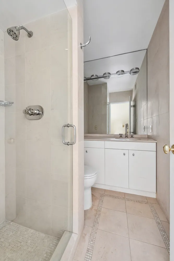 a bathroom with a white bath tub a mirror and a shower