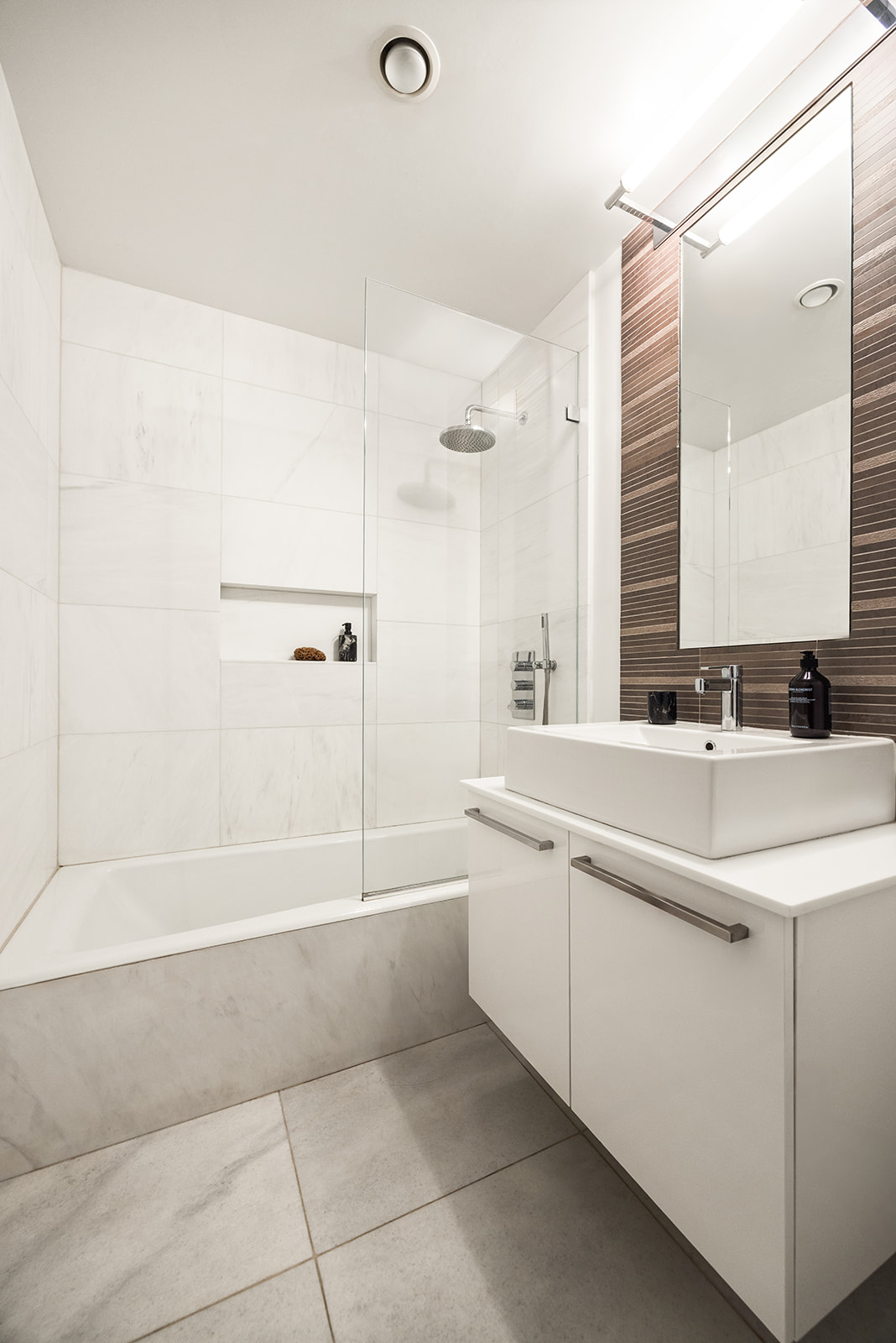 133 West 22nd Street, Unit 8G Manhattan, NY 10011 - Photo 10 of 16 a bathroom with a bathtub sink vanity and mirror
