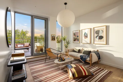 a roof deck with couches and potted plants with sky view