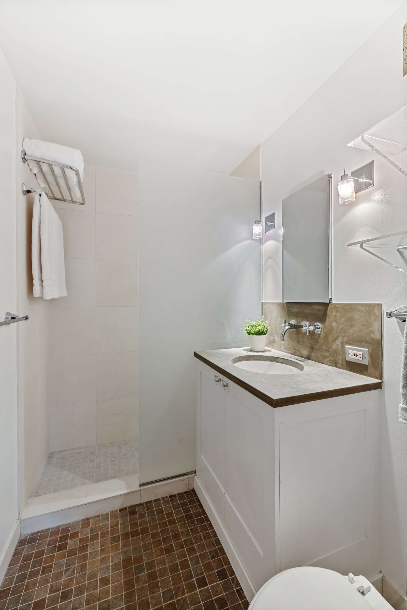 99 Bank Street, Unit 7E Manhattan, NY 10014 - Photo 7 of 8 a bathroom with a sink a toilet and shower