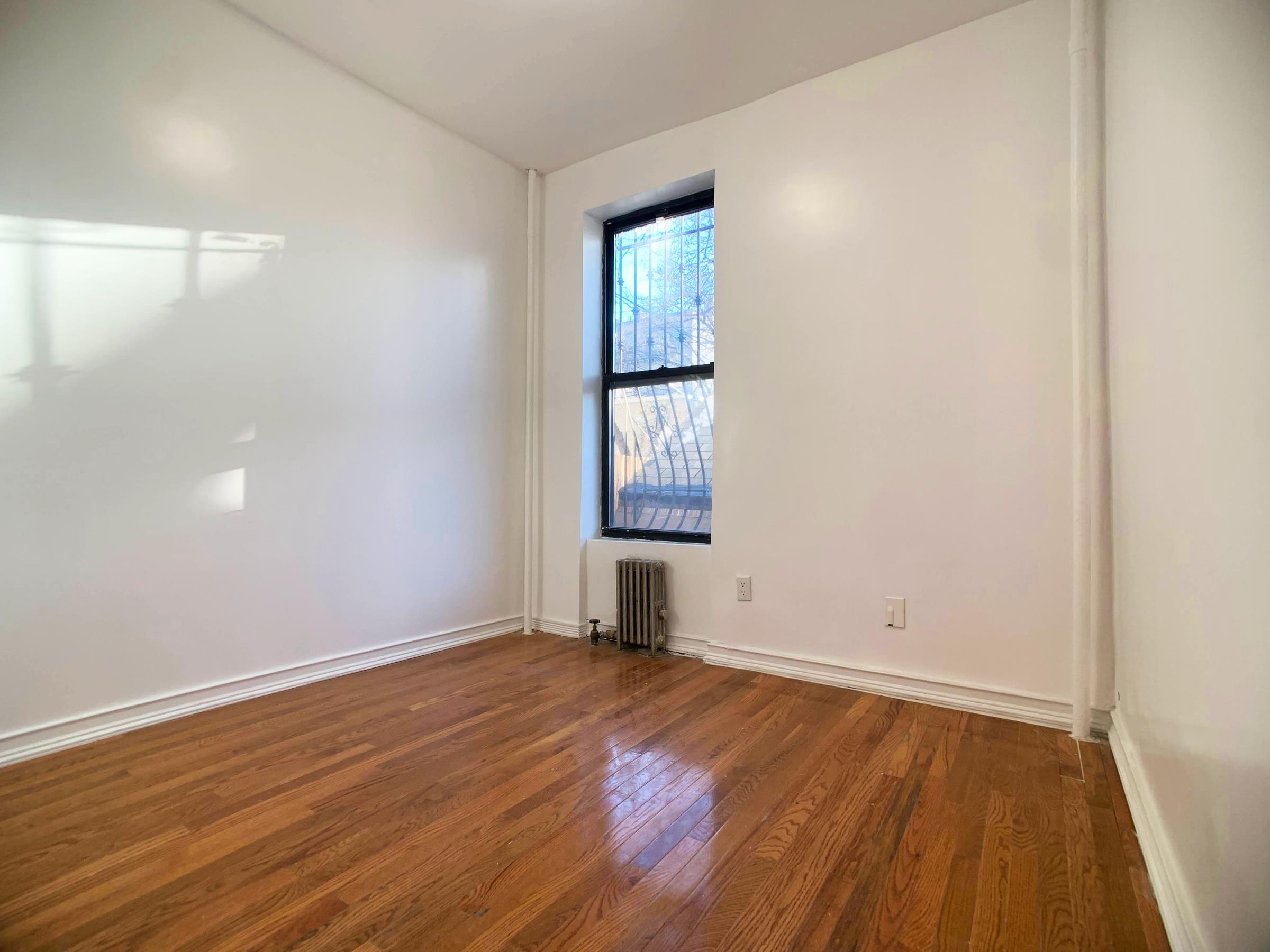 630 President Street, Unit 1 Brooklyn, NY 11215 - Photo 8 of 11 an empty room with wooden floor and windows