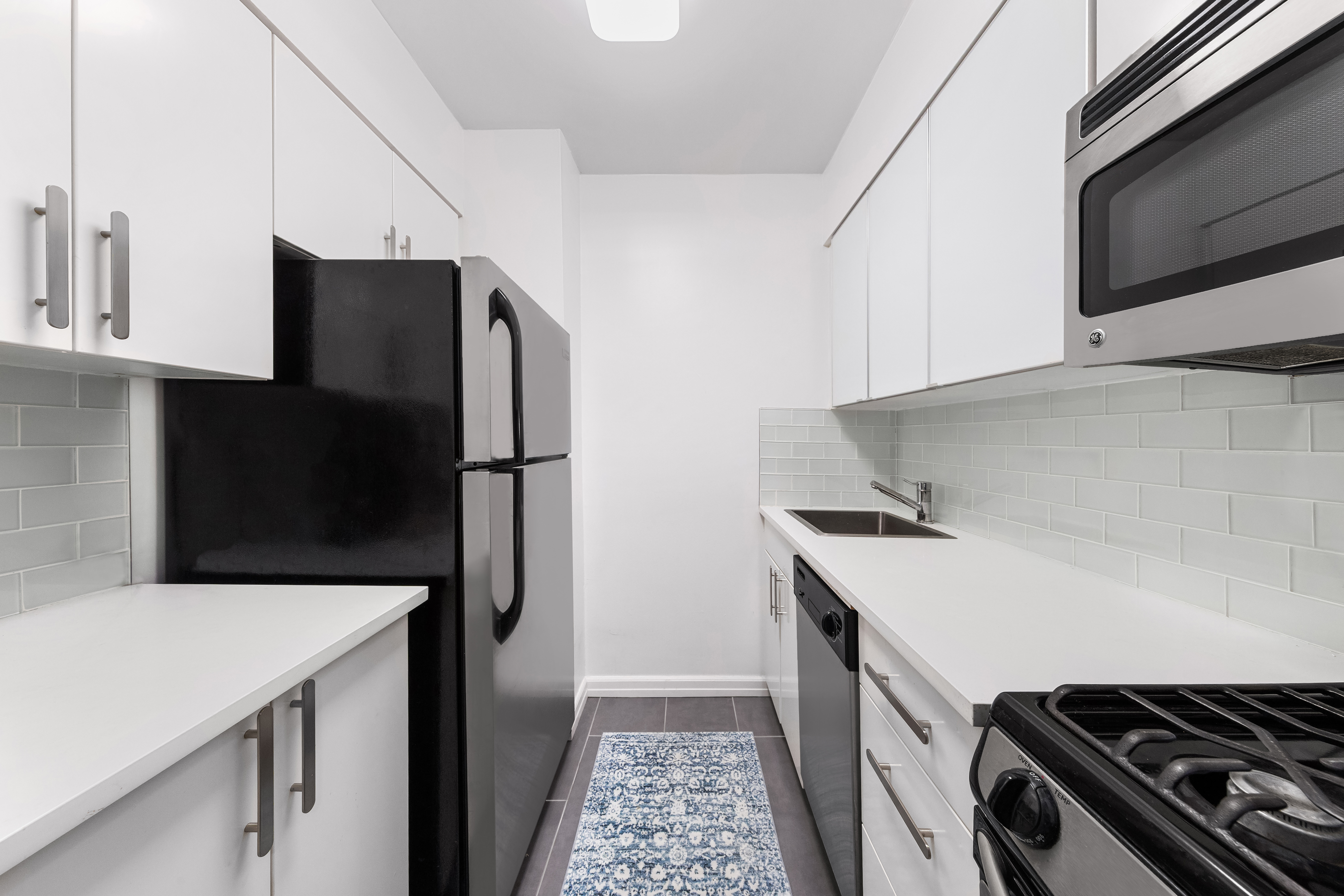 301 East 45th Street, Unit 11F Manhattan, NY 10017 - Photo 3 of 9 a kitchen with stainless steel appliances a refrigerator and a stove