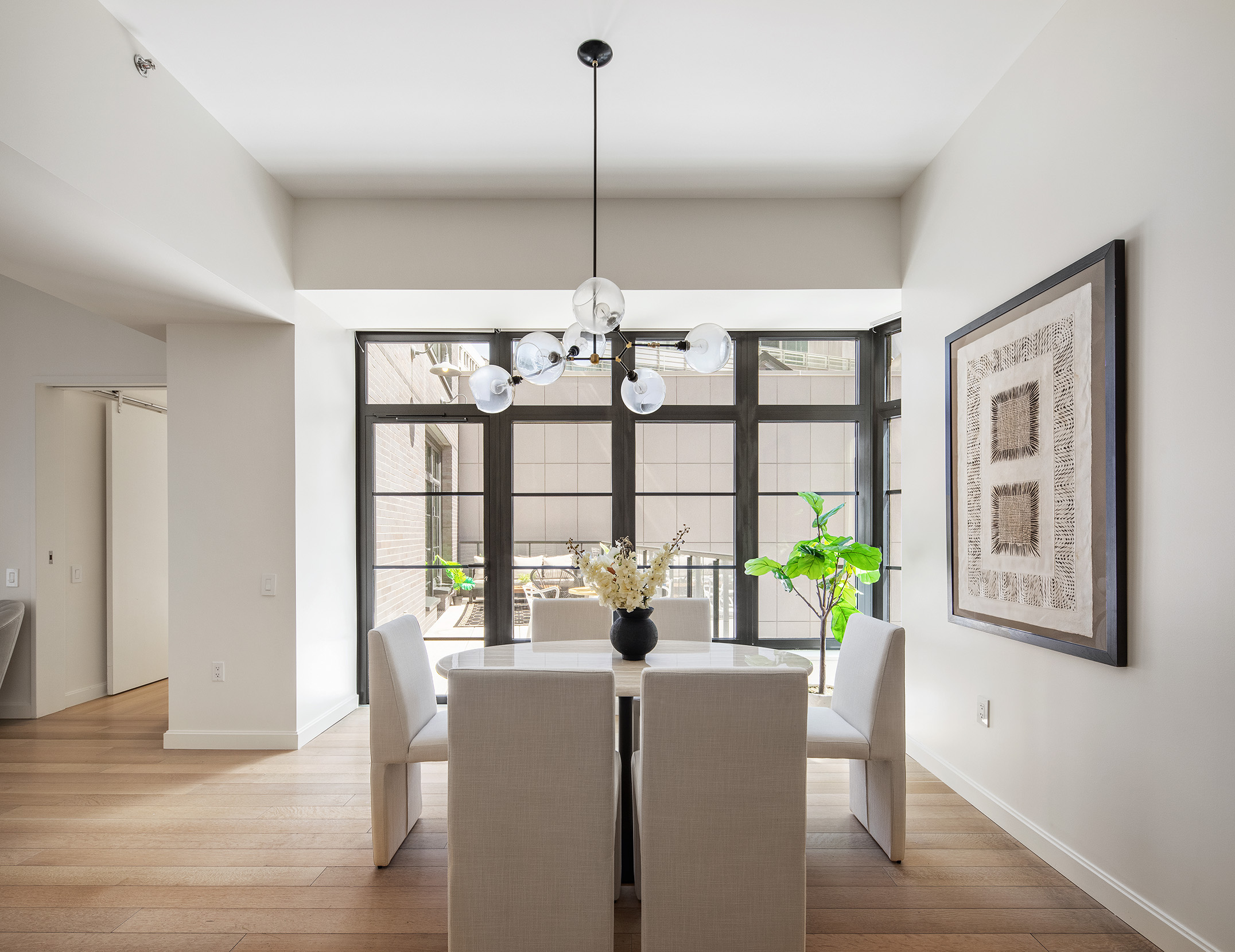 50 West 30th Street, Unit 3E Manhattan, NY 10001 - Photo 2 of 9 a dining room with furniture a chandelier and wooden floor