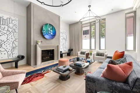 a living room with furniture a fireplace and a chandelier