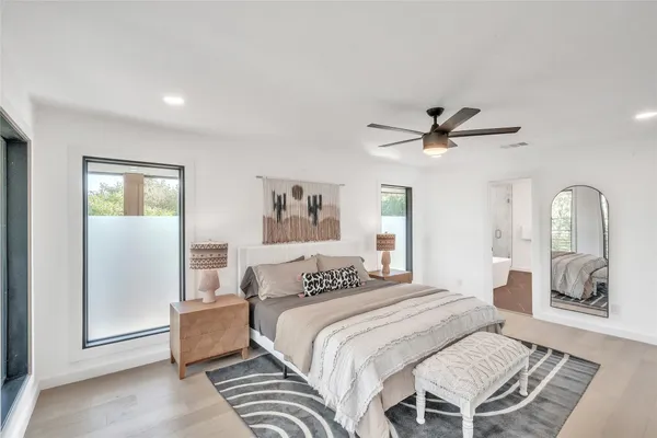 a bedroom with a large bed and a chandelier