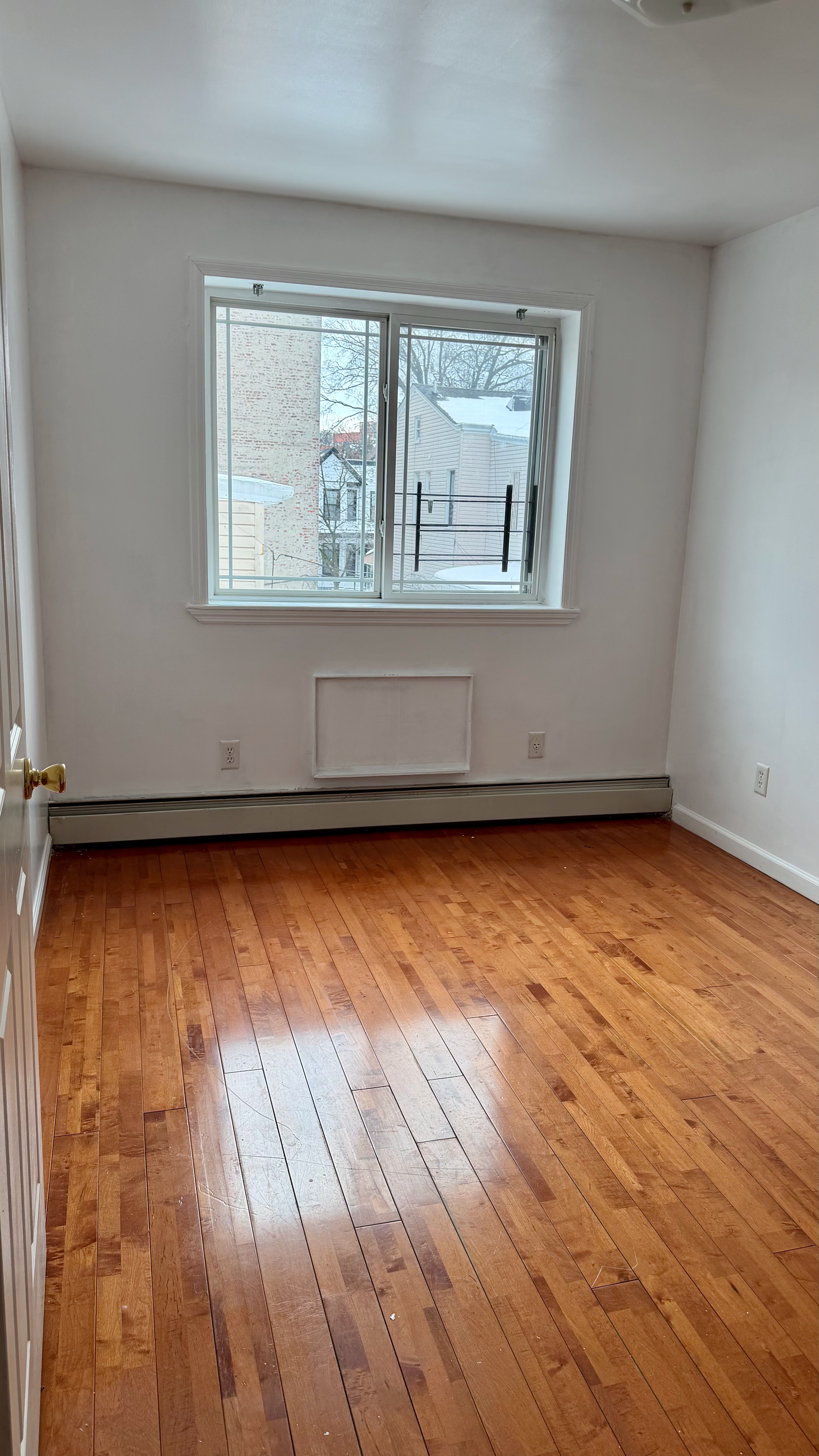 48 Schenck Avenue, Unit 3 Brooklyn, NY 11207 - Photo 4 of 7 an empty room with wooden floor and windows