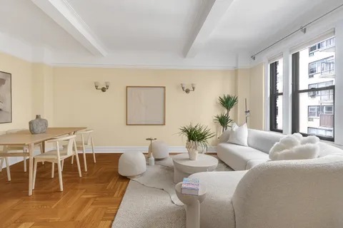 a living room with furniture a table and a large window