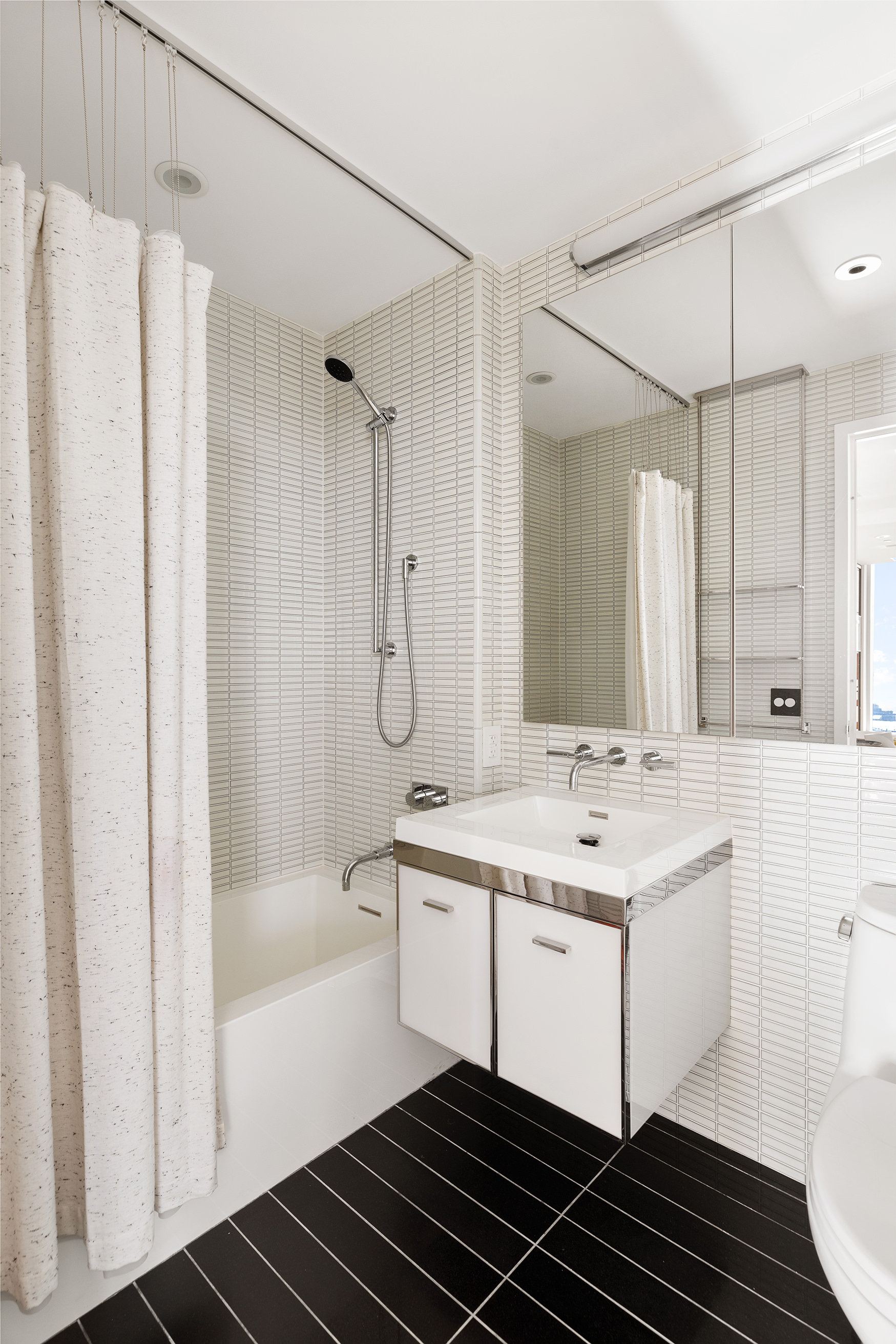 252 South Street, Unit 43C Manhattan, NY 10002 - Photo 8 of 10 a bathroom with a sink a mirror and a shower