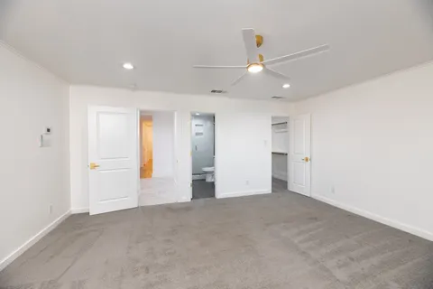 an empty room with closet and a ceiling fan