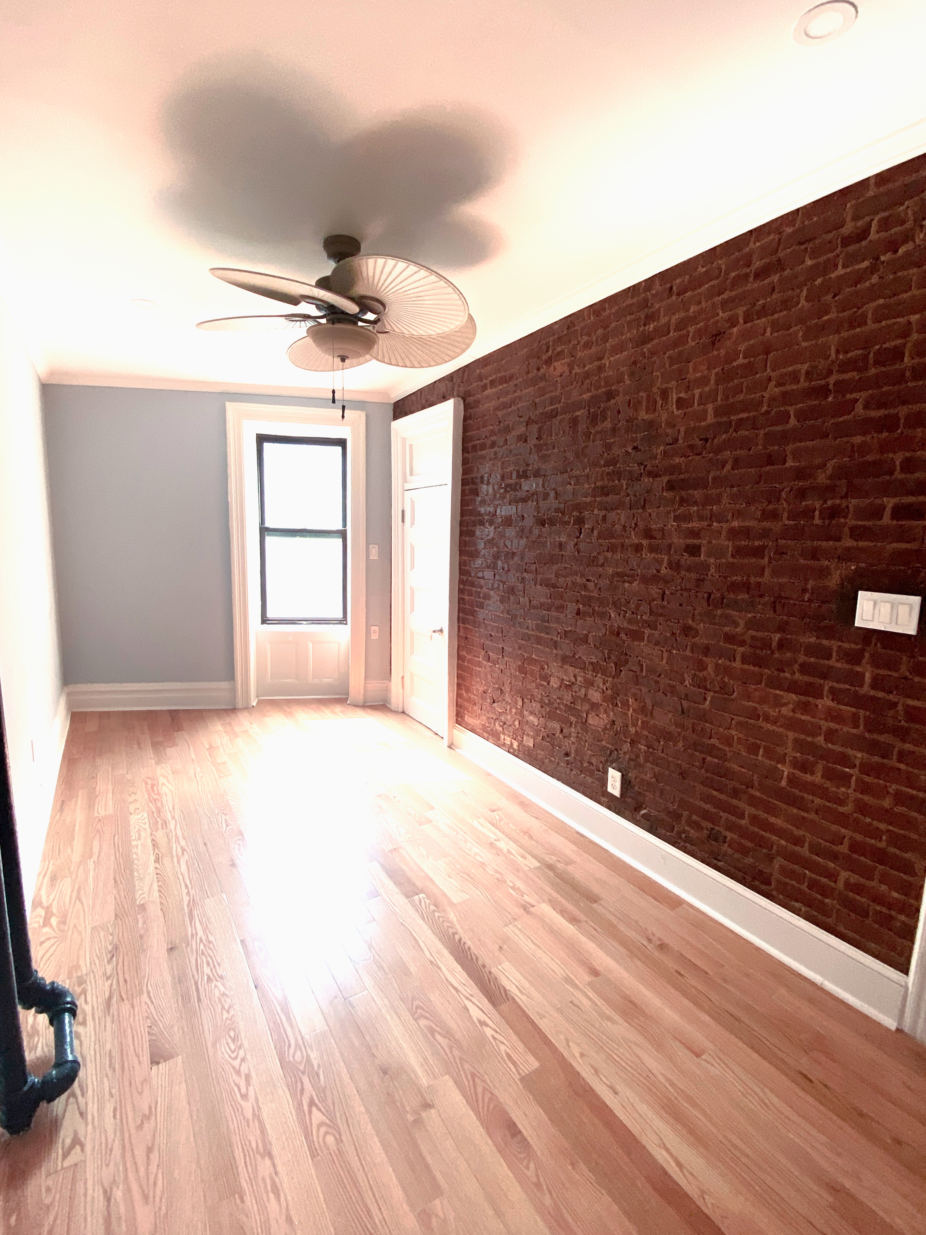 100 Hamilton Place, Unit 2F Manhattan, NY 10031 - Photo 13 of 21 a view of empty room with wooden floor and fan