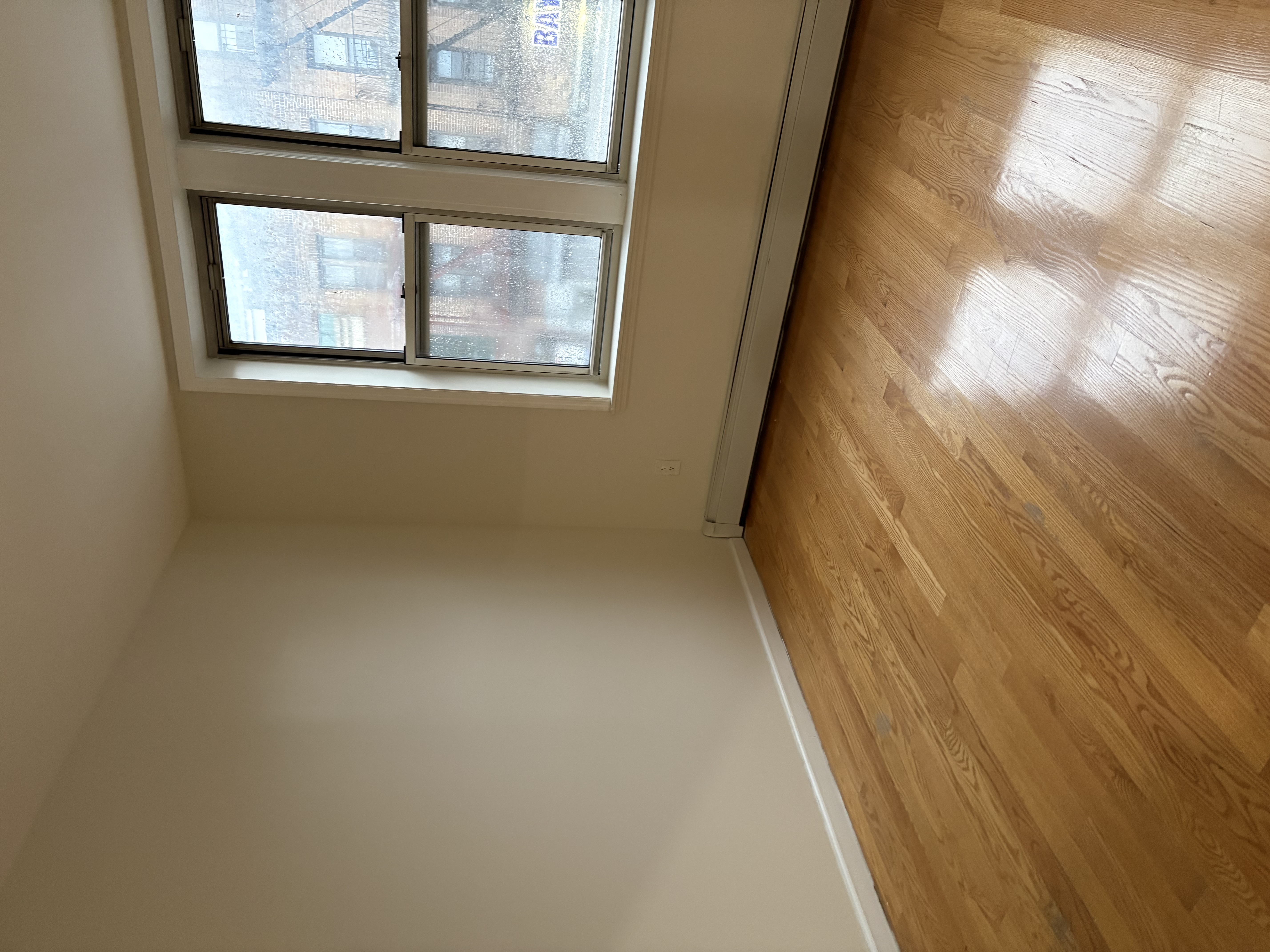 8703 5th Avenue, Unit 2F Brooklyn, NY 11209 - Photo 6 of 9 an empty room with wooden floor and windows