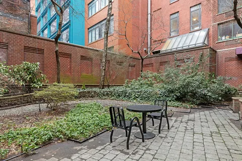 a backyard of a house with table and chairs and plants