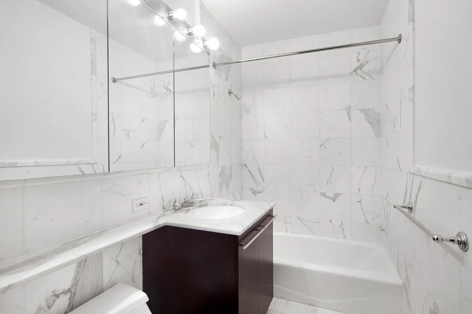 a bathroom with a sink vanity granite tub shower and a mirror