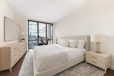 a spacious bedroom with a large bed and a large window