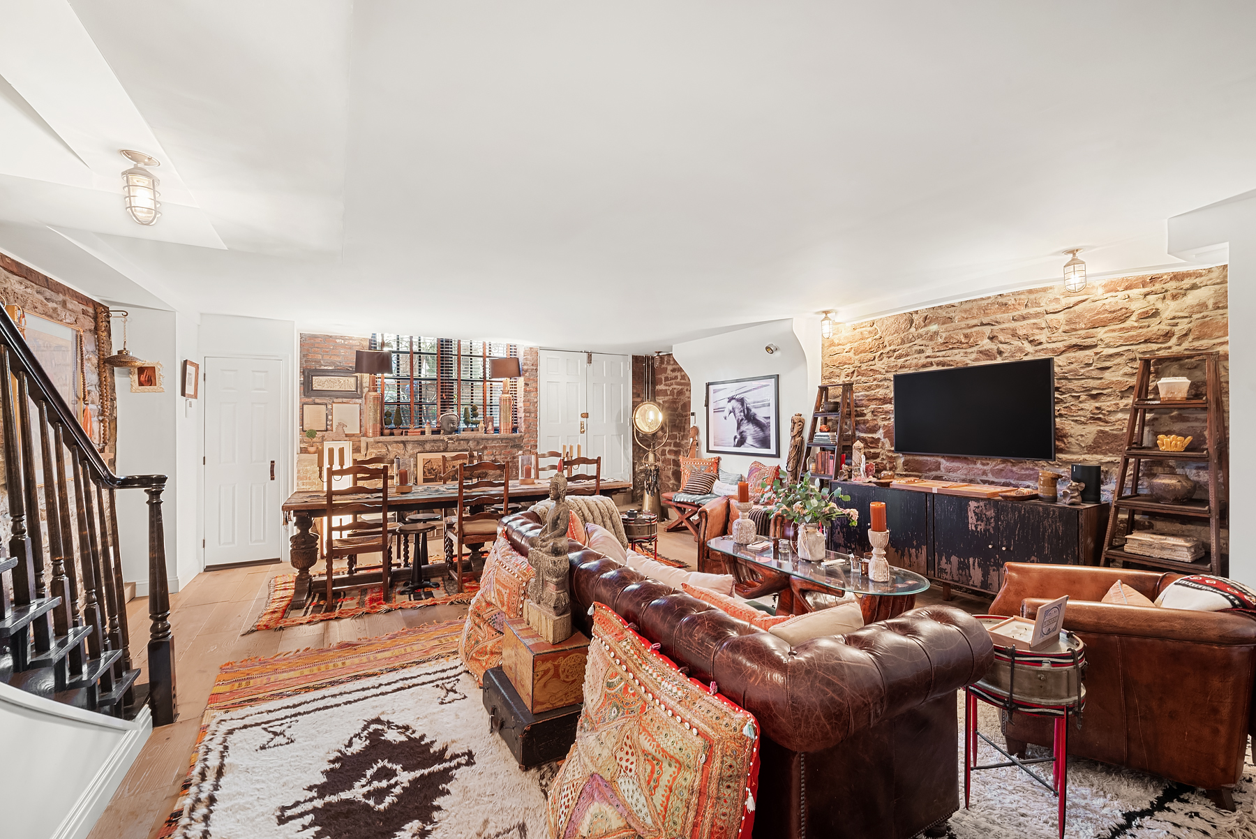 57 Sullivan Street, Unit DUPLEX Manhattan, NY 10012 - Photo 3 of 9 a living room with furniture a flat screen tv and a fireplace