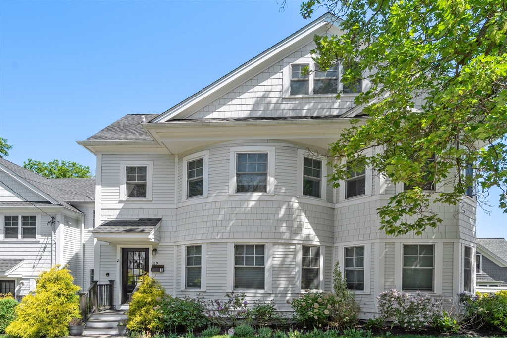 a front view of a house with a garden and plants