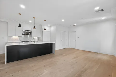 a kitchen with kitchen island sink and cabinets