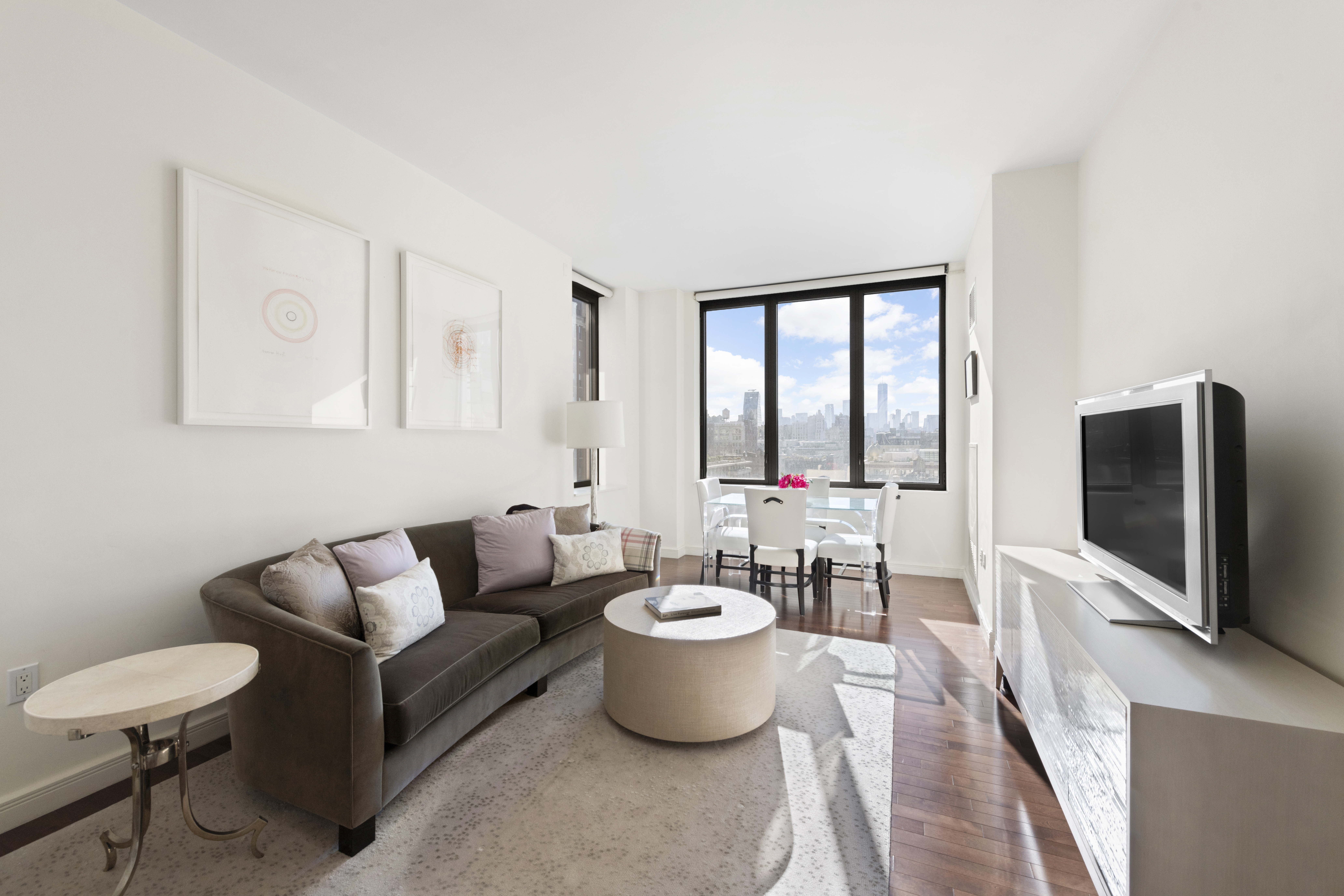 101 West 24th Street, Unit 12C Manhattan, NY 10011 - Photo 1 of 17 a living room with furniture a flat screen tv and large window