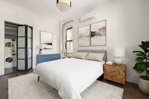 a bedroom with a bed and a potted plant