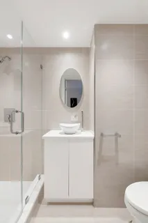 a bathroom with a sink a toilet and shower