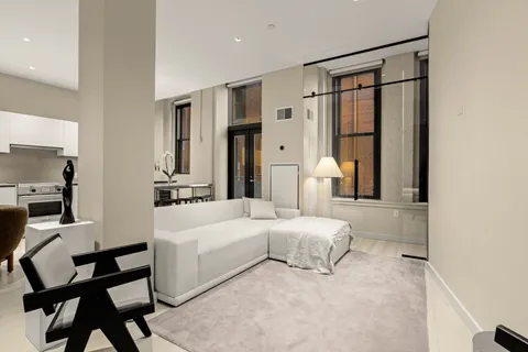 a bedroom with a large bed and a chandelier