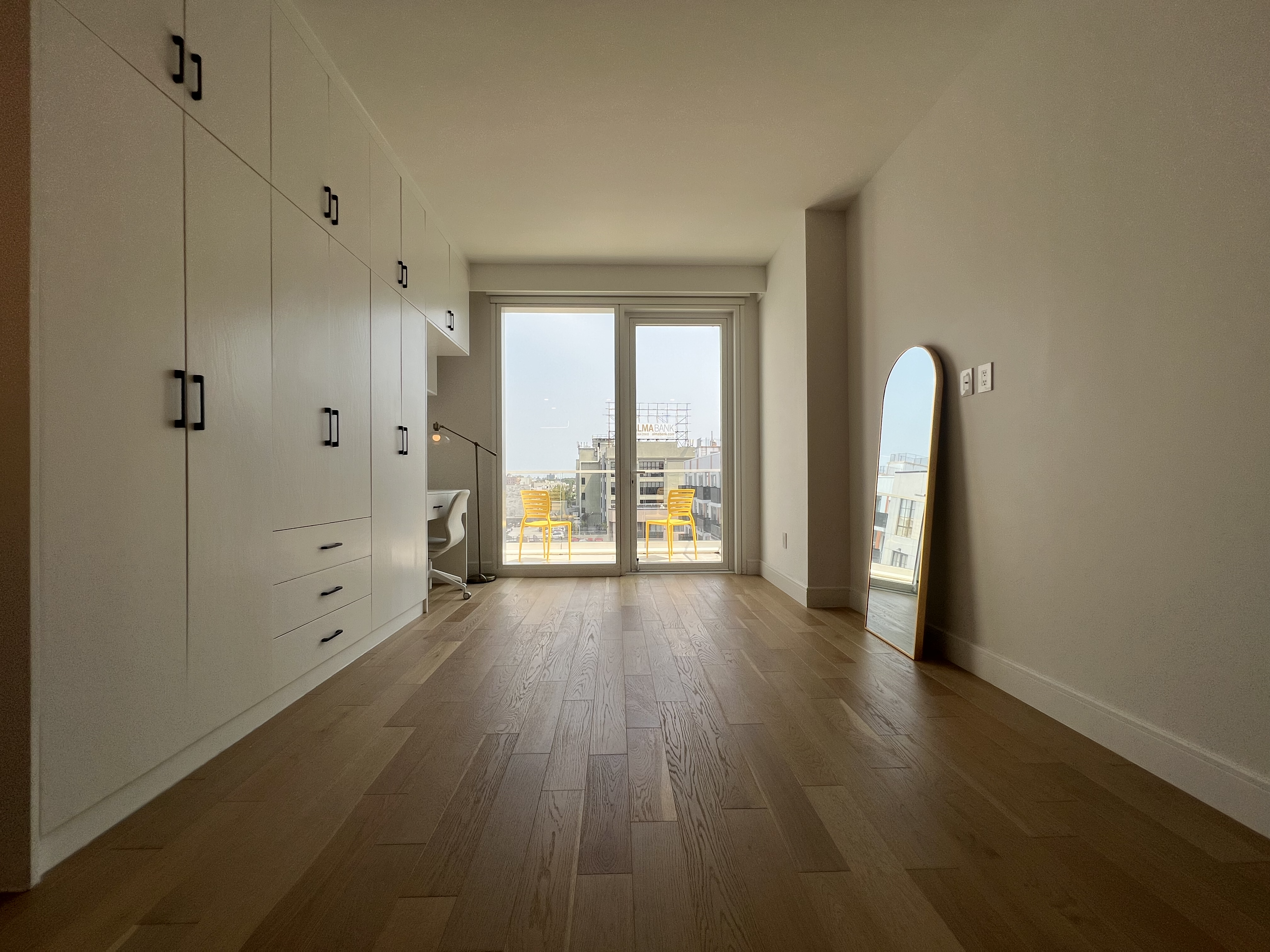 37-34 33rd Street, Unit 7H Queens, NY 11101 - Photo 5 of 18 wooden floor in an empty room with a window