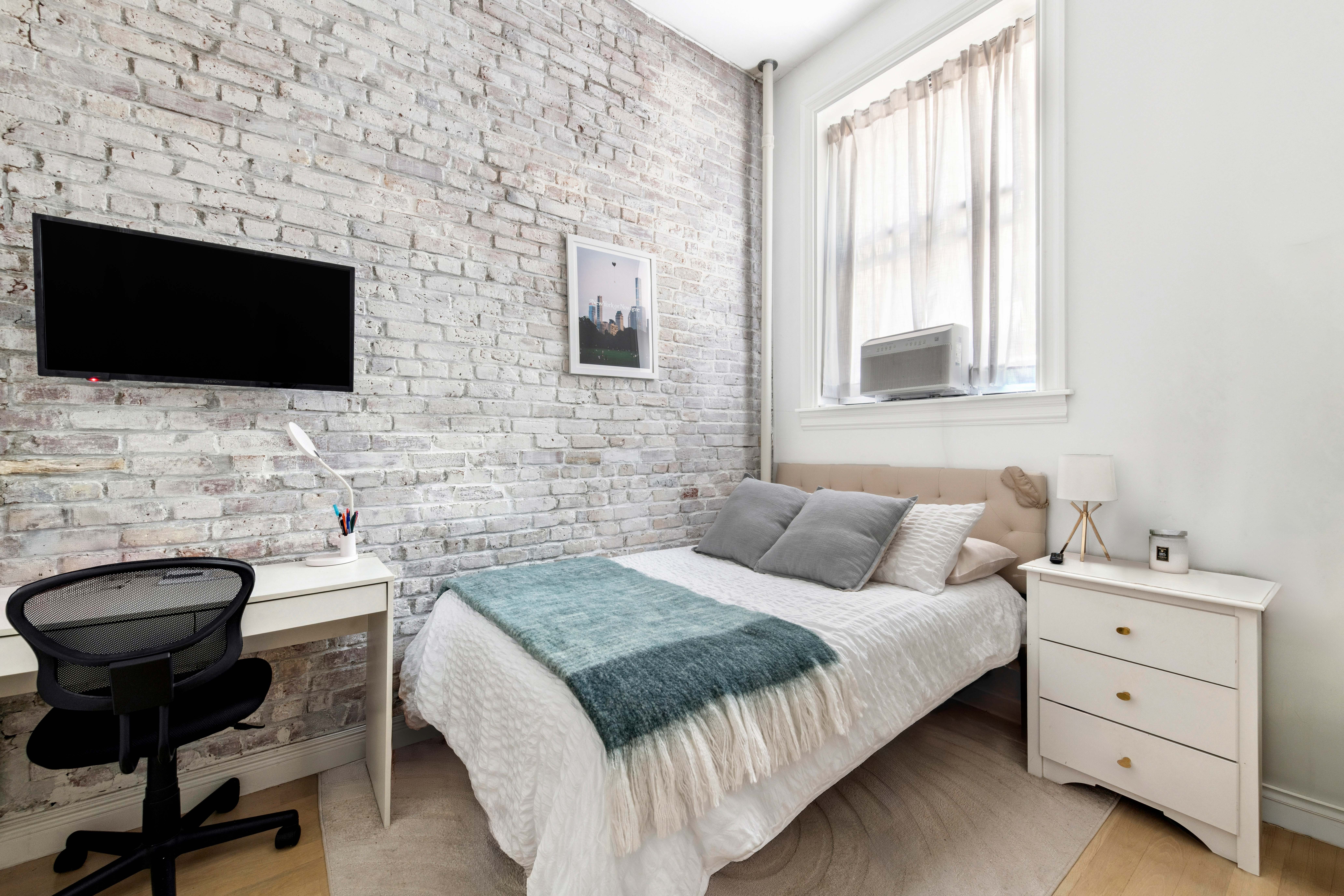 51 West 11th Street, Unit 1R Manhattan, NY 10011 - Photo 4 of 10 a bedroom with a bed and a flat screen tv