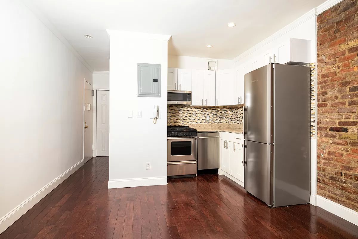 328 West 19th Street, Unit 1B Manhattan, NY 10011 - Photo 8 of 11 a kitchen with stainless steel appliances a refrigerator and a hard wood floor