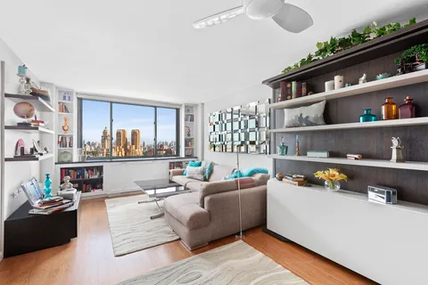 a living room with furniture cabinets and a window