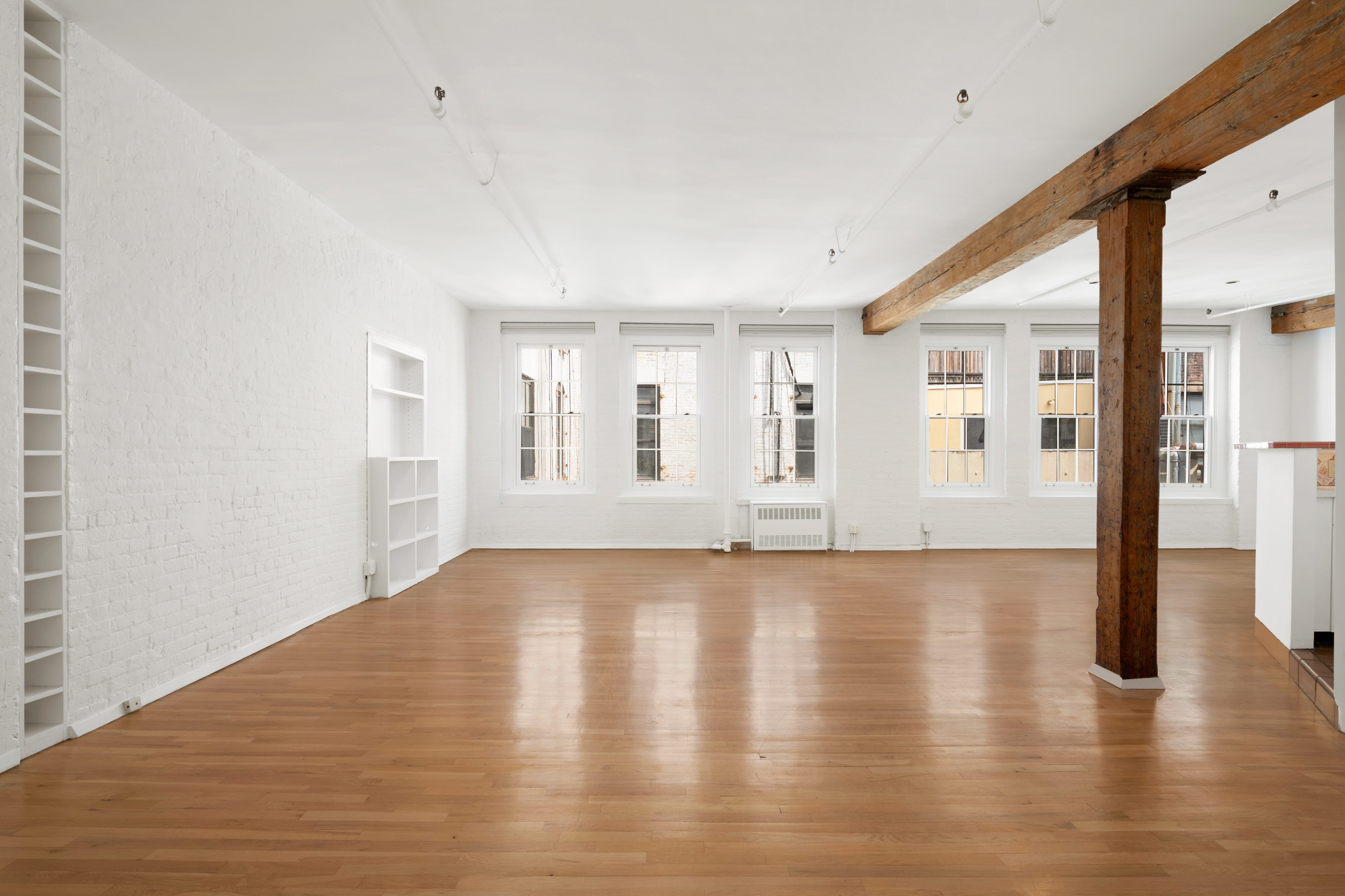 140 Thompson, Unit 4A Manhattan, NY 10012 - Photo 3 of 13 a view of an empty room with wooden floor and a window