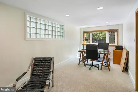 a view of a workspace with furniture and a window
