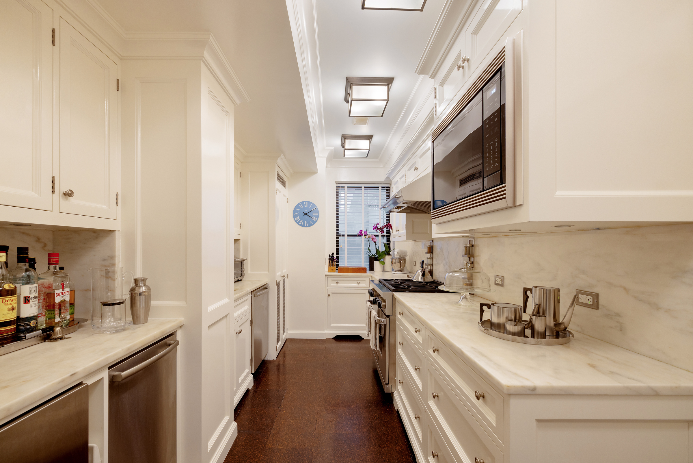 419 East 57th Street, Unit 6A Manhattan, NY 10022 - Photo 3 of 13 a kitchen with stainless steel appliances a sink dishwasher stove microwave and cabinets