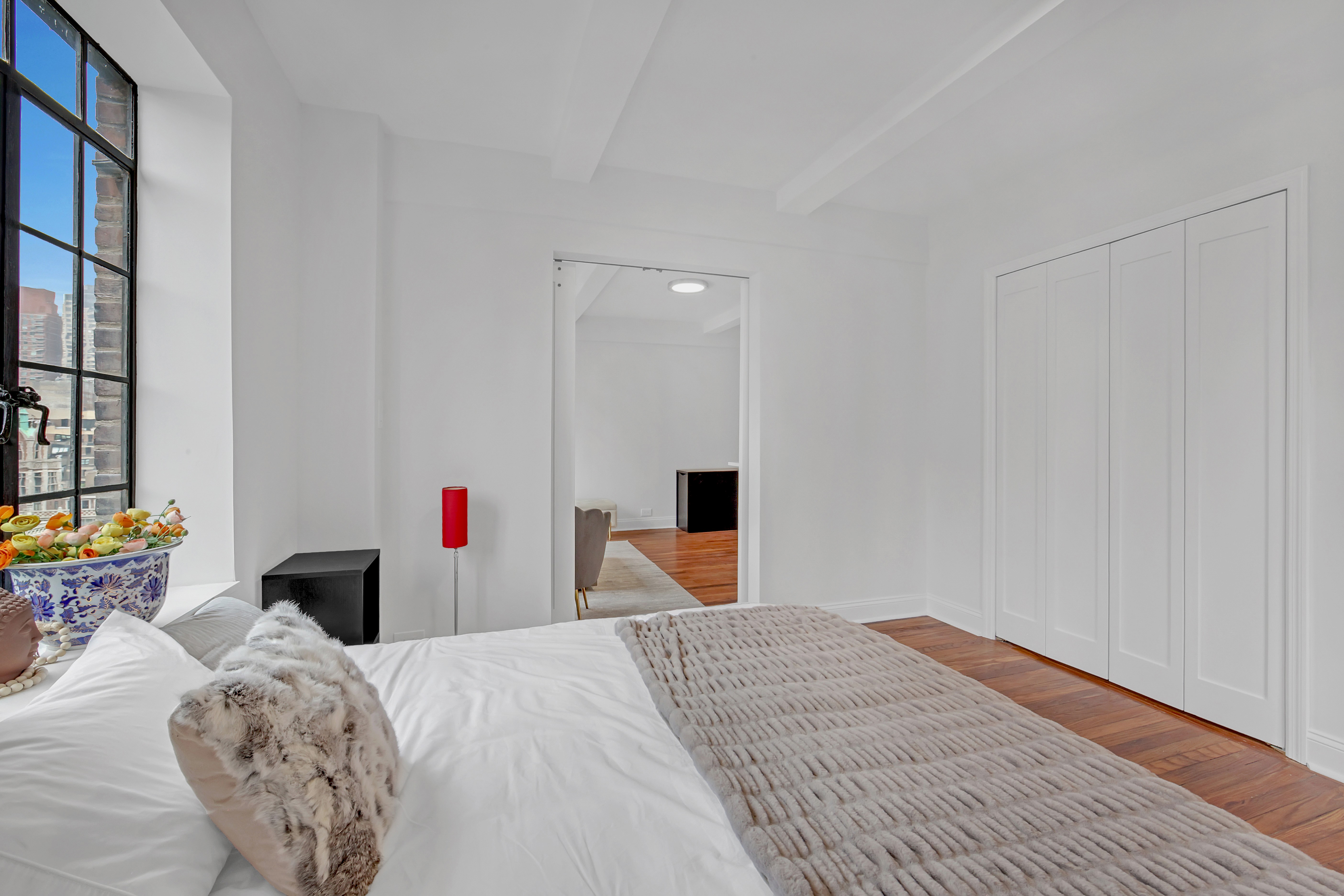 25 Tudor City Place, Unit 1405 Manhattan, NY 10017 - Photo 9 of 21 a bedroom with a bed and a chandelier