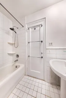 a bathroom with a granite countertop sink a mirror and a bathtub