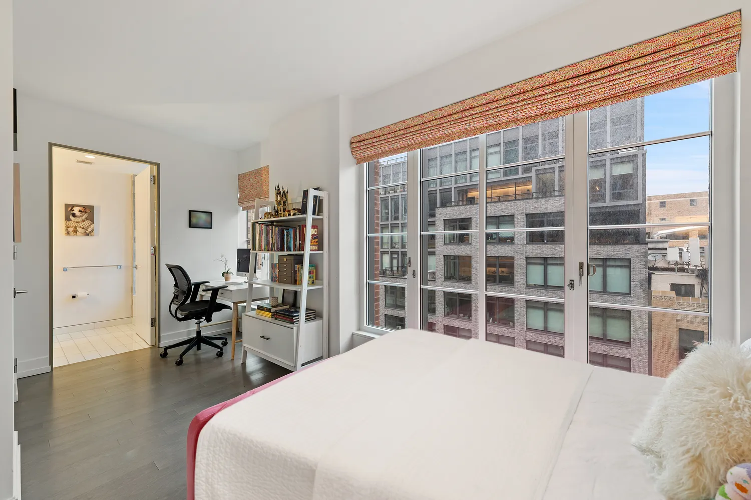 a bedroom with a bed and a large window