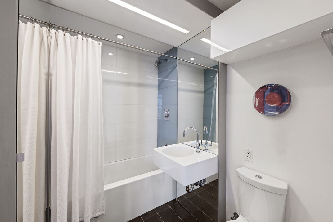 2 Northside Piers, Unit 8H Brooklyn, NY 11249 - Photo 12 of 20 a bathroom with a sink a toilet and shower