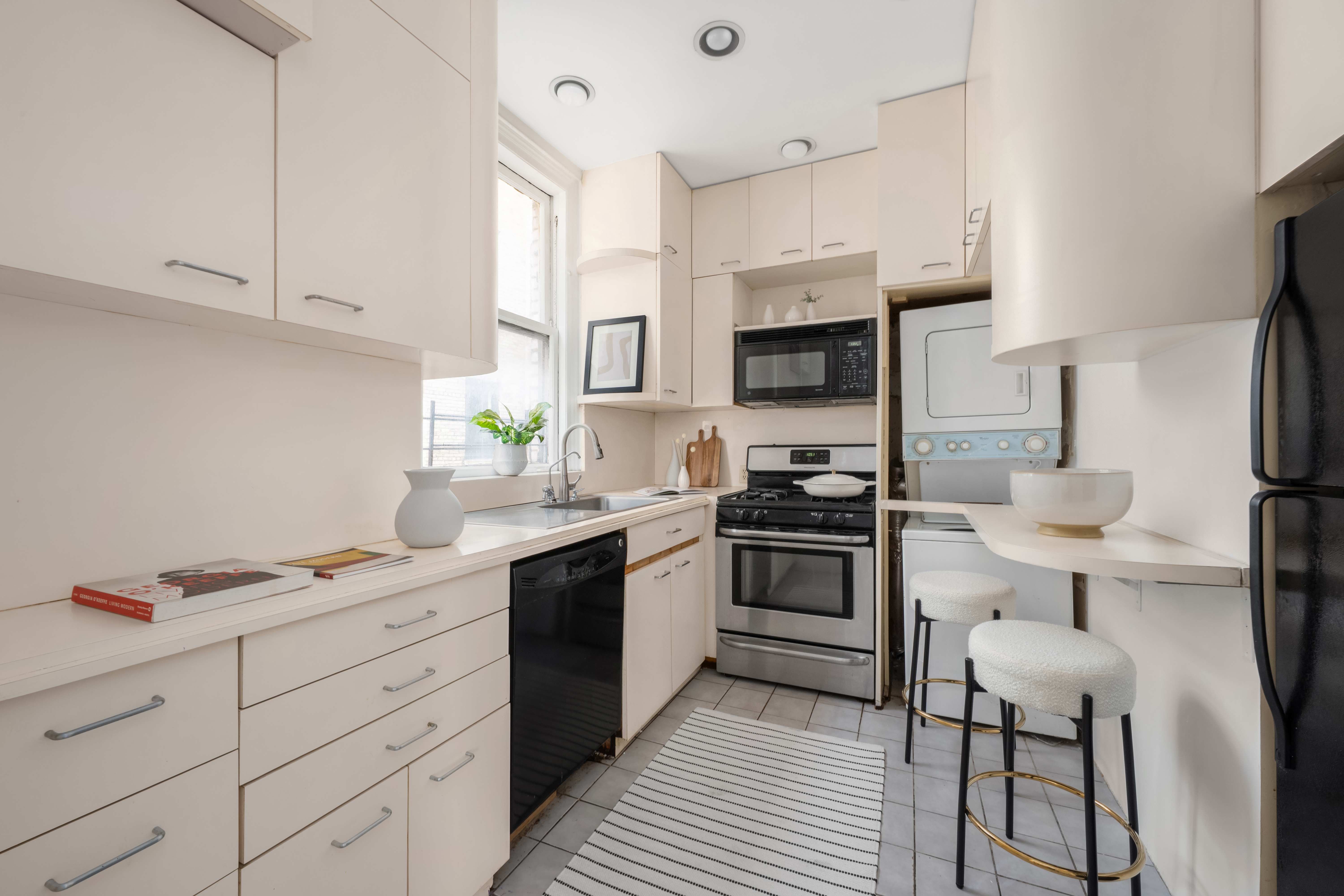 1060 Park Avenue, Unit 11A Manhattan, NY 10128 - Photo 8 of 12 a kitchen with stainless steel appliances a stove refrigerator sink and microwave
