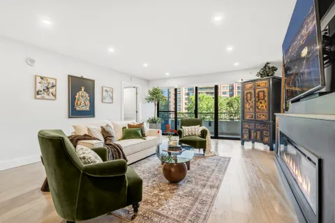 a living room with furniture large window and wooden floor