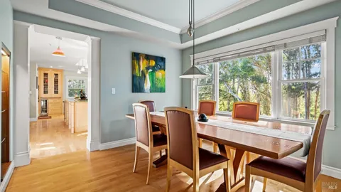 a dining room with furniture a chandelier and wooden floor