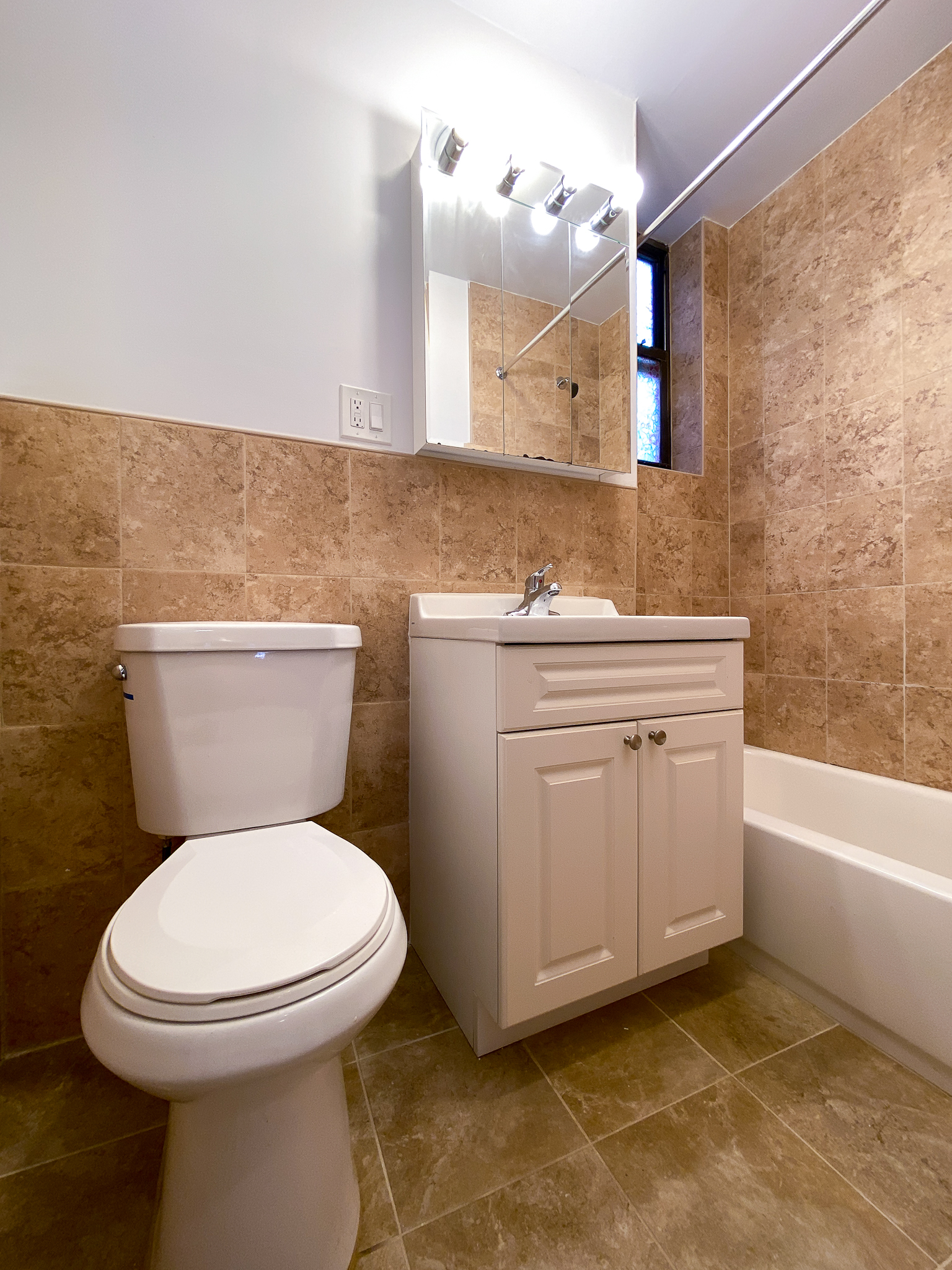 319 East 25th Street, Unit 3C Manhattan, NY 10010 - Photo 7 of 12 a bathroom with a sink a toilet and mirror
