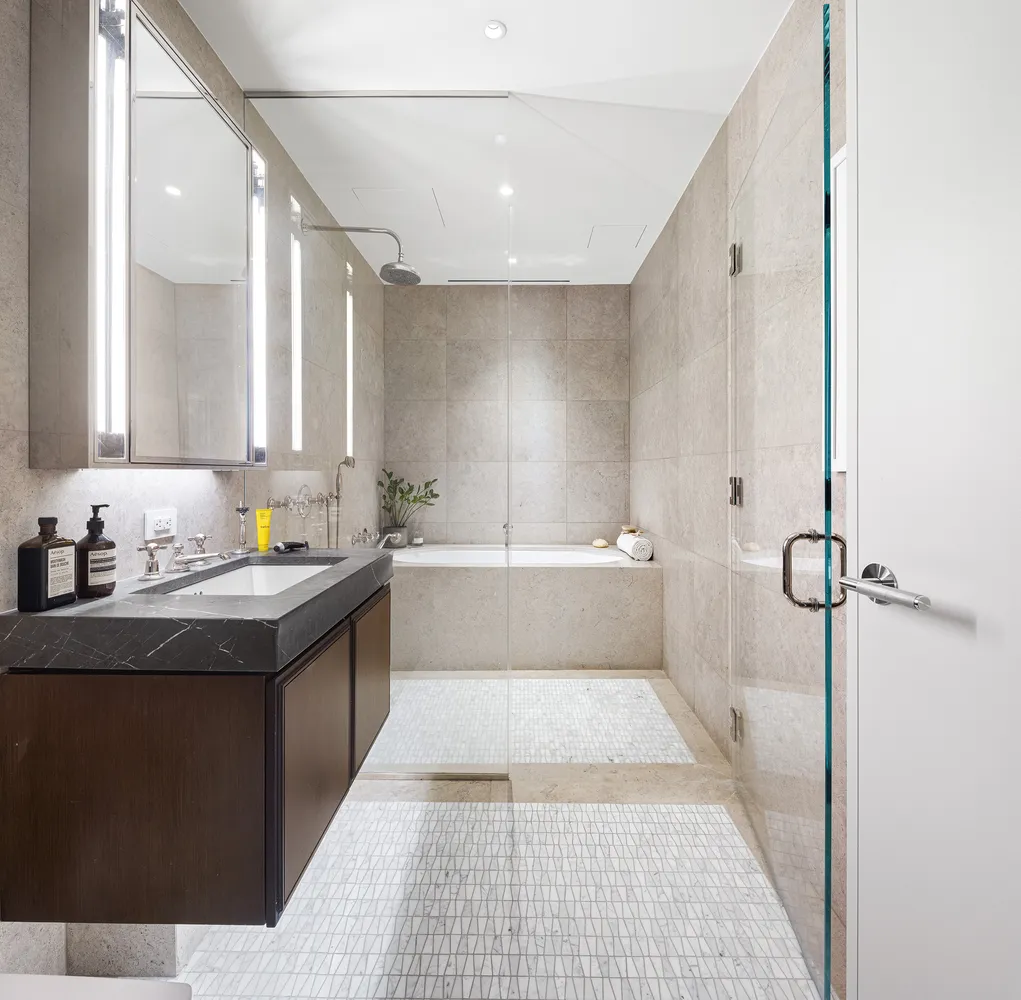a bathroom with a granite countertop sink a mirror and a bathtub