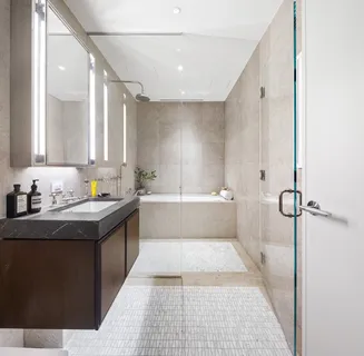 a bathroom with a granite countertop sink a mirror and a bathtub