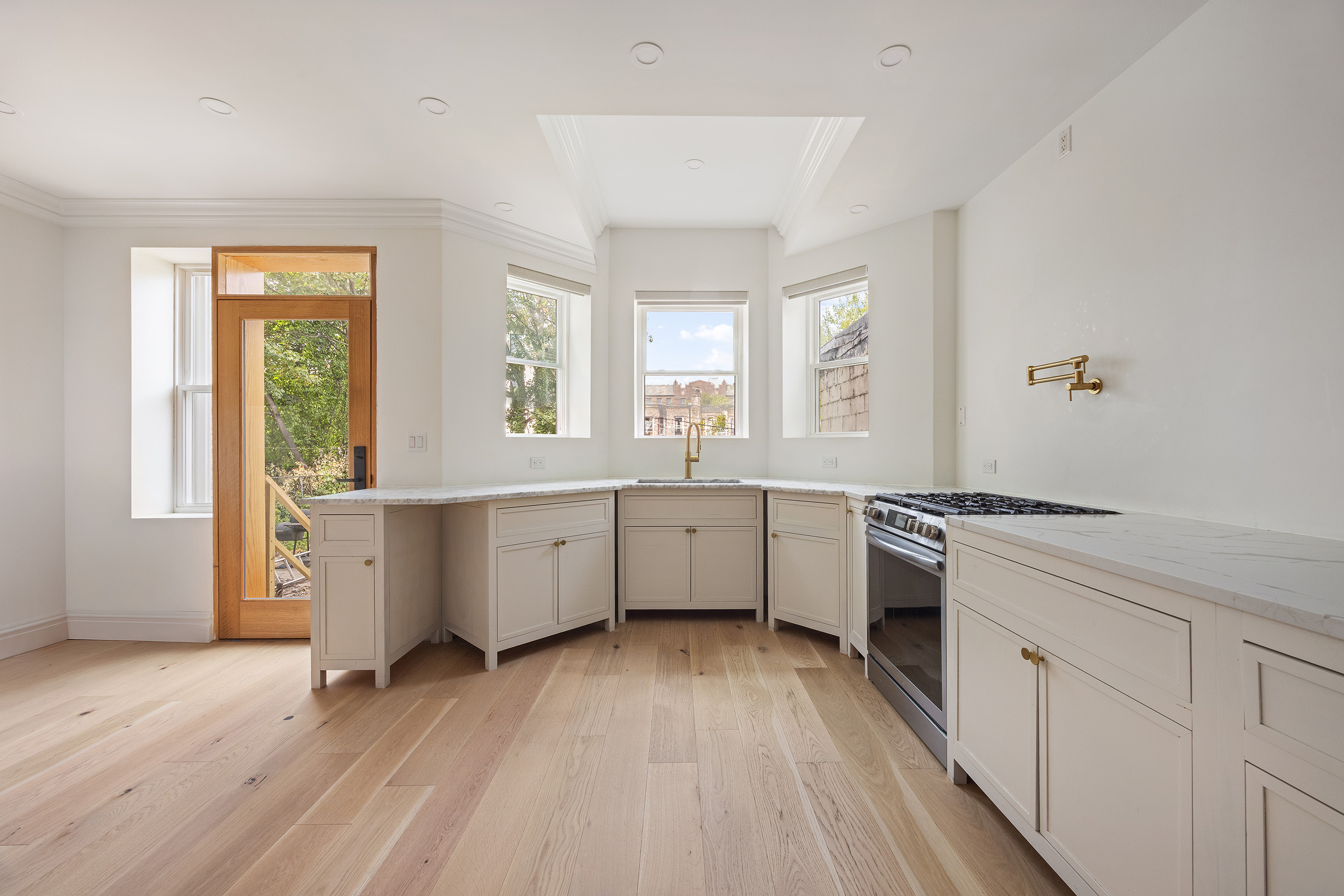 1423 Park Place Brooklyn, NY 11213 - Photo 8 of 17 a large kitchen with a wooden floor and a stove top oven