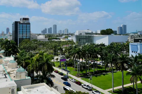 a view of a city with tall buildings and a big yard