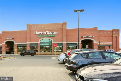 a front view of a building with cars parked