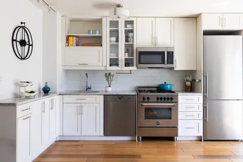 a kitchen with stainless steel appliances granite countertop a refrigerator and a stove top oven