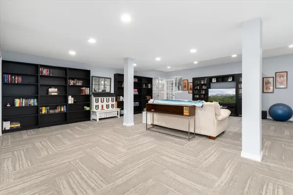 a living room with furniture and a book shelf