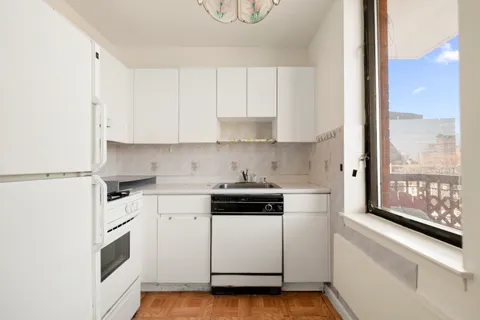 a kitchen with a stove and a white cabinets