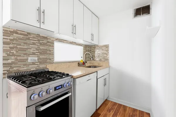 a kitchen with a stove and white cabinets
